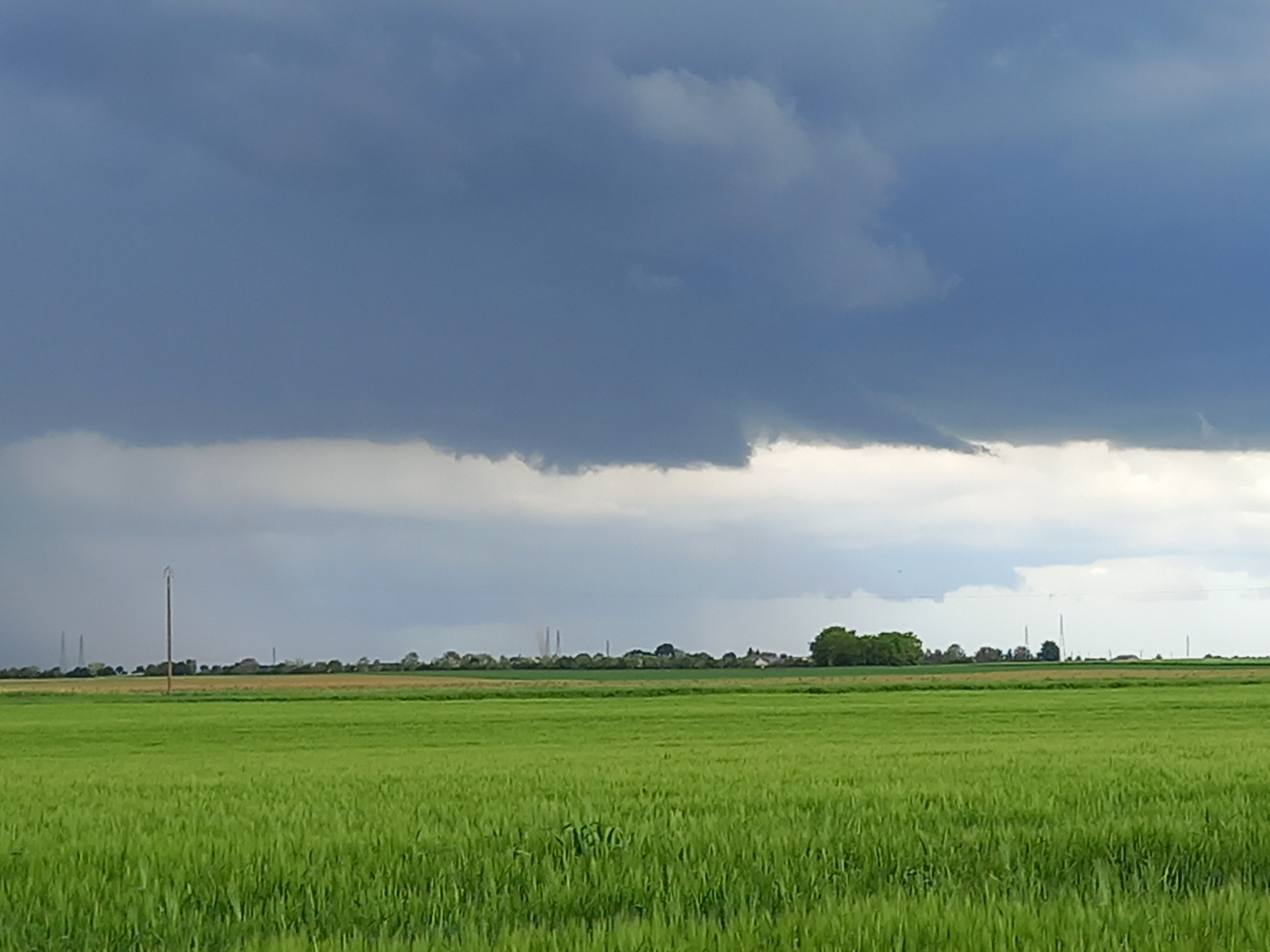 Vue depuis Janville, début de la tornade de Loigny la Bataille avec seulement le buisson visible(au centre juste à gauche des 2 poteaux électriques), le reste de la tornade n'étant pas condensée. - 18/05/2024 16:13 - Thierry REIBELL